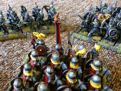 Back view of a Dwarf regiment getting assaulted by two Dark Elf units from the front