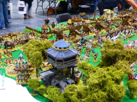View over a wooden tower in a forest onto a Barbarian army with war mammoths and other beasts