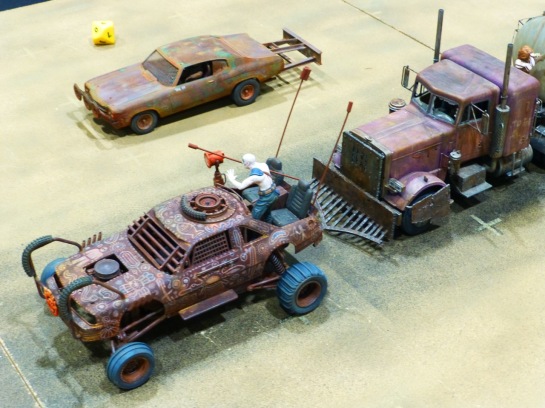 Closer view of converted model cars with rusted and painted bodywork