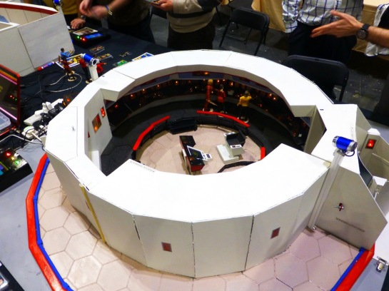 A round model of a command bridge with Star Trek action figures placed inside