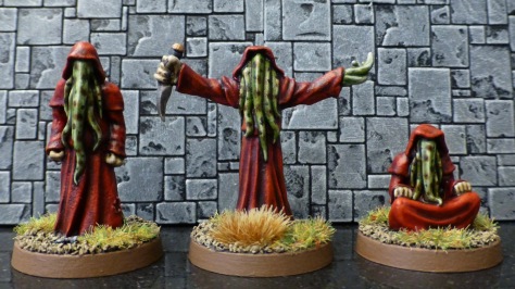 Three humanoid figures in red robes with tentacles in place of faces
