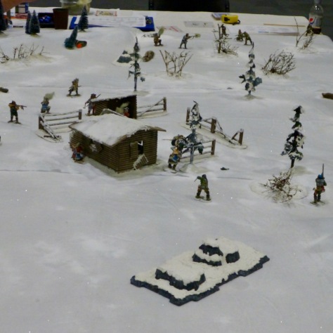 Log cabin in a snowy winter landscape with individual fighters skirmishing