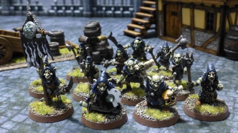 Group of twelve green skinned goblins with black hoods