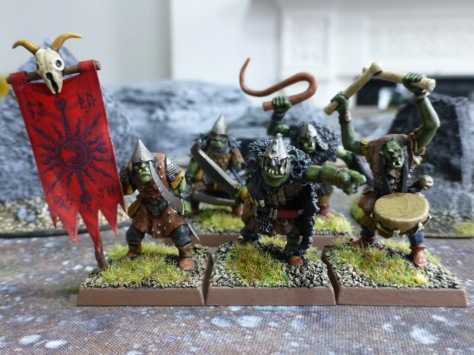 Group of five goblins including a standard bearer with red banner and a musician with drums