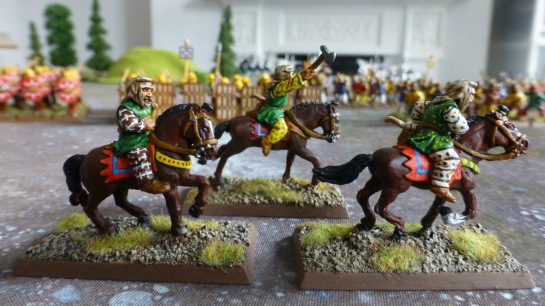 Side view of three Persian horse archers in colourful tunics and trousers