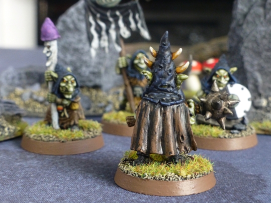 Back view of goblin leader wearing a brown tattered cloak