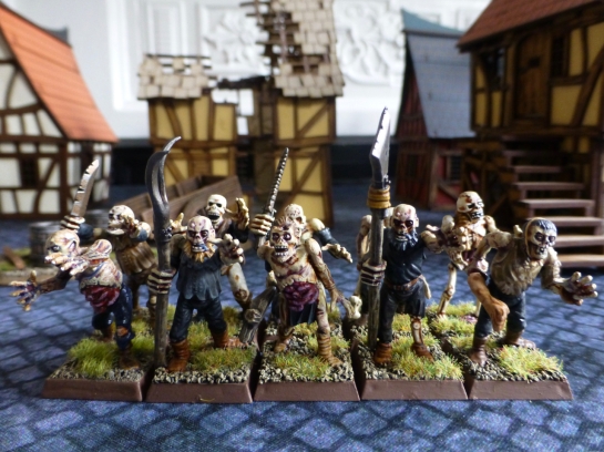 Two ranks of zombies with crude weapons and pitchforks